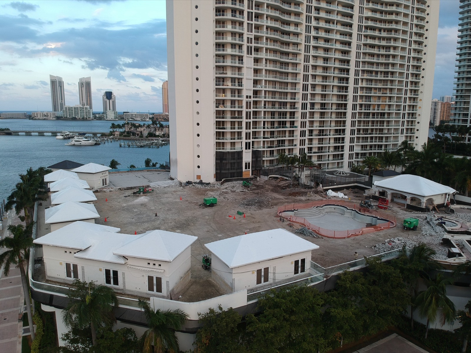Coastal condominium high-rise with shrink wrapped roofs after a hurricane