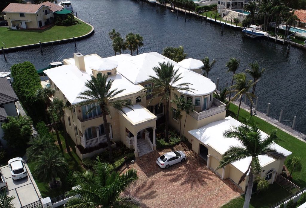 Waterfront mansion on the intracoastal with a white shrink wrapped roof