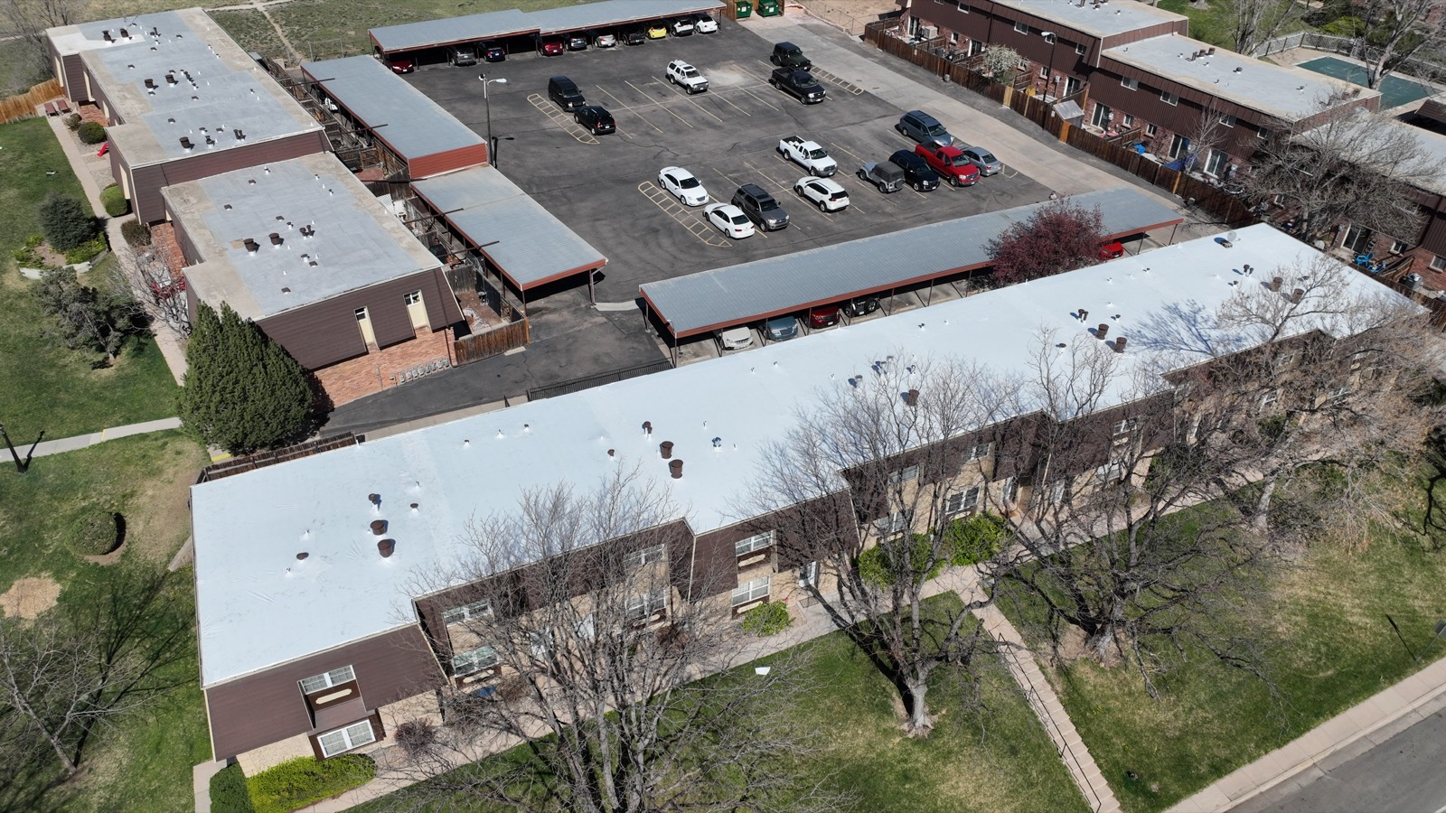 Commercial plaza with a white shrink wrapped roof, drone view