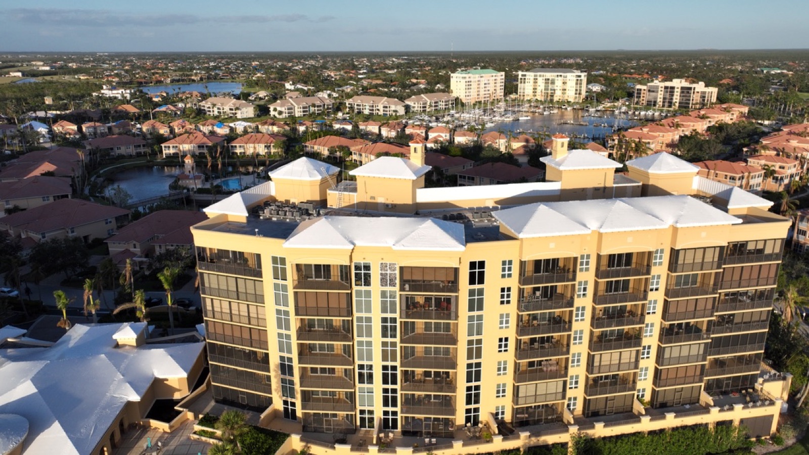 Condominium association tower roofs sealed in white shrink wrap after a hurricane