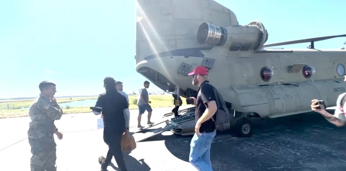 Titanium Tarps disaster response crew boarding a military Chinook helicopter to reach a hurricane zone cut off by road