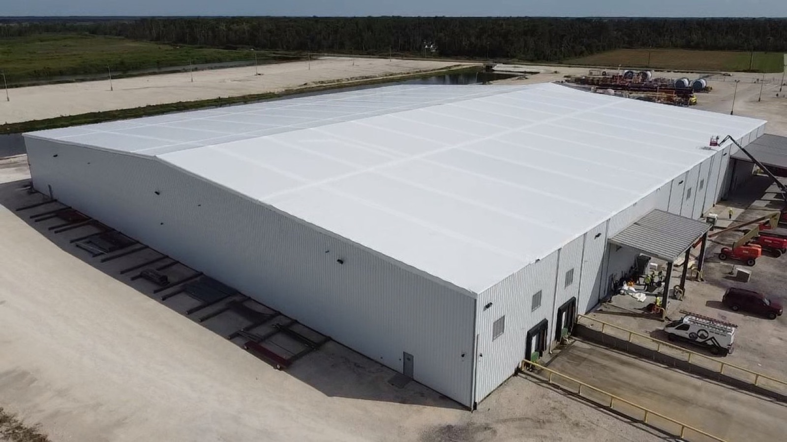 Large commercial building roof sealed under white Elastowrap after storm damage