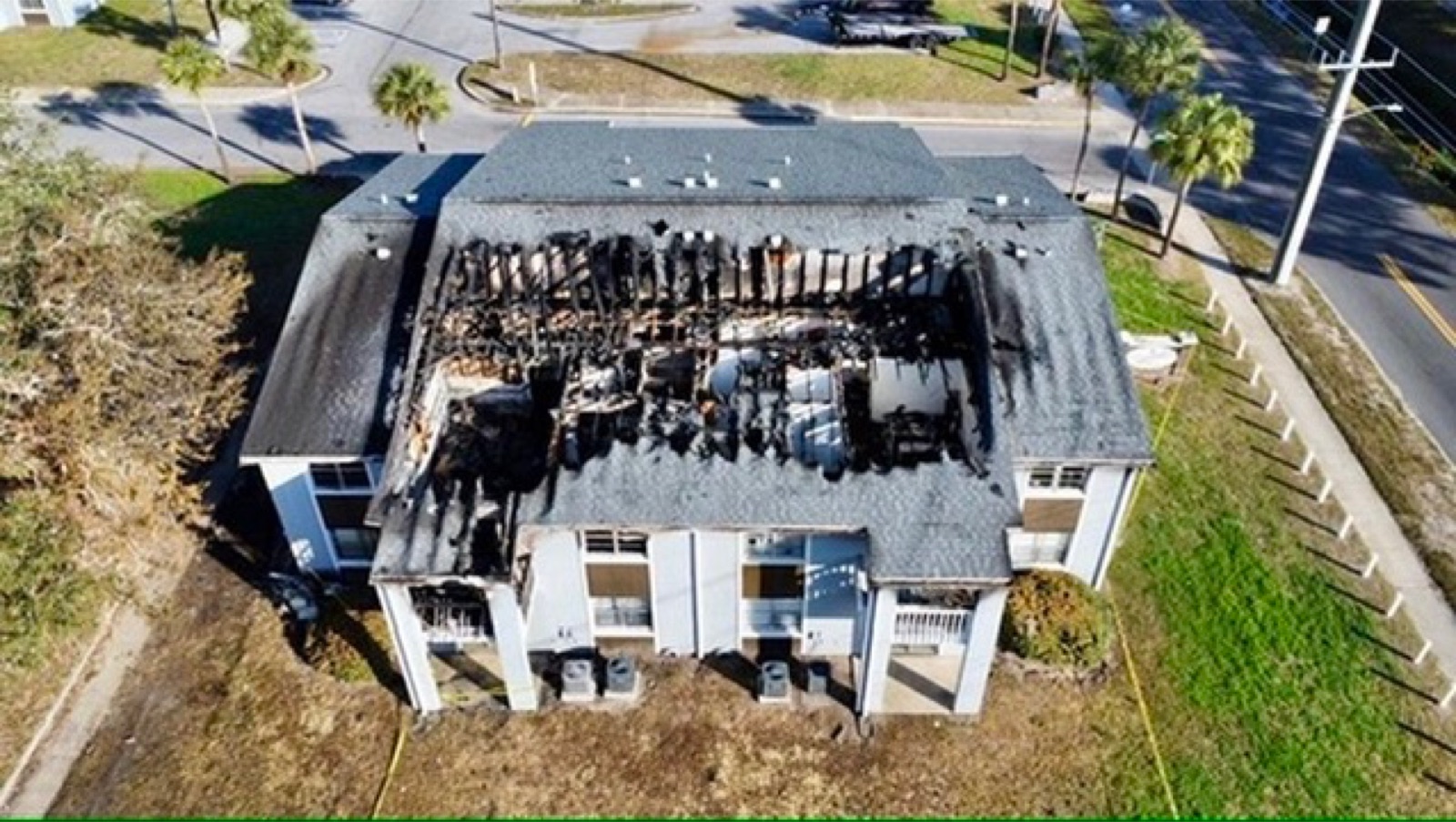 Fire damaged apartment building roof before emergency weather protection
