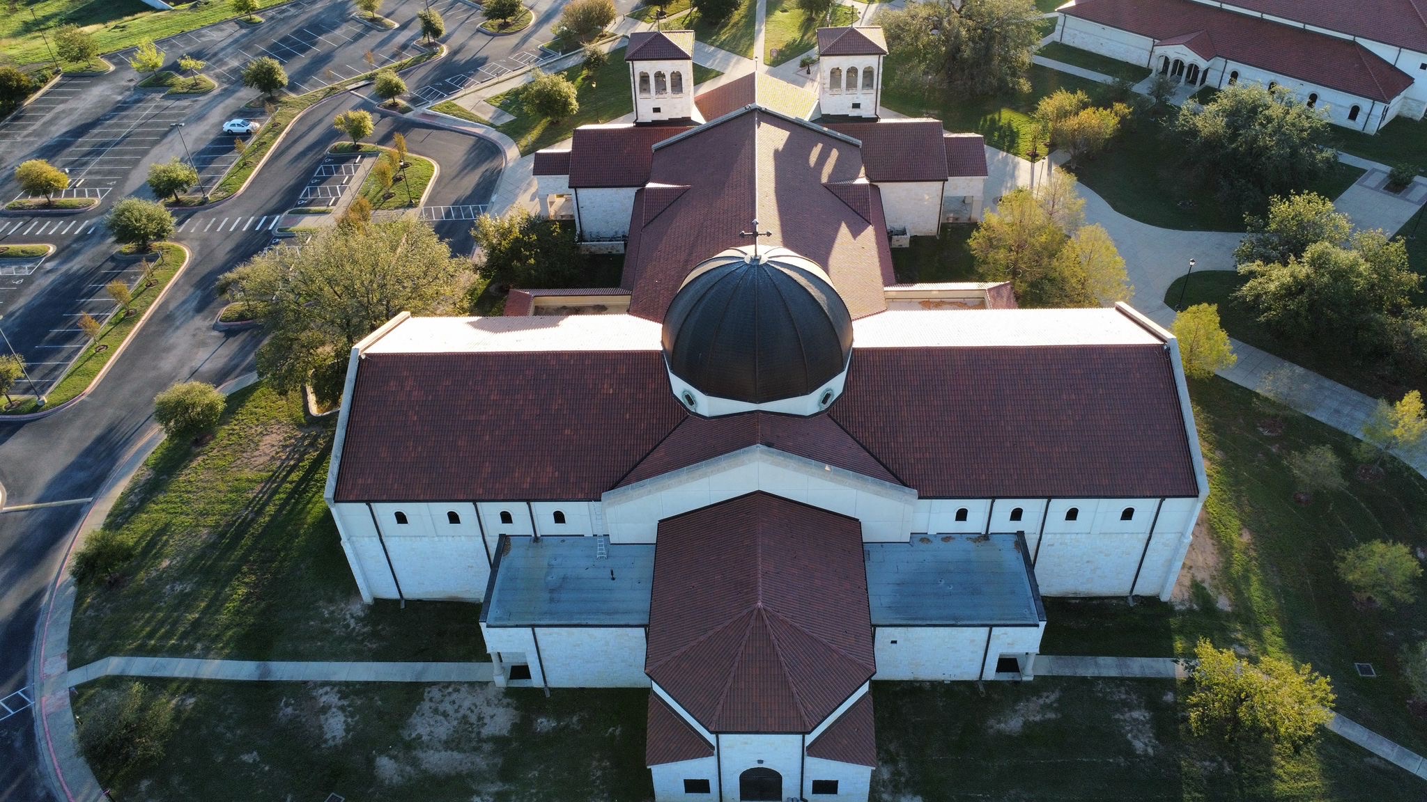 Cross-shaped church building with its original tile roof before Titanium Tarps