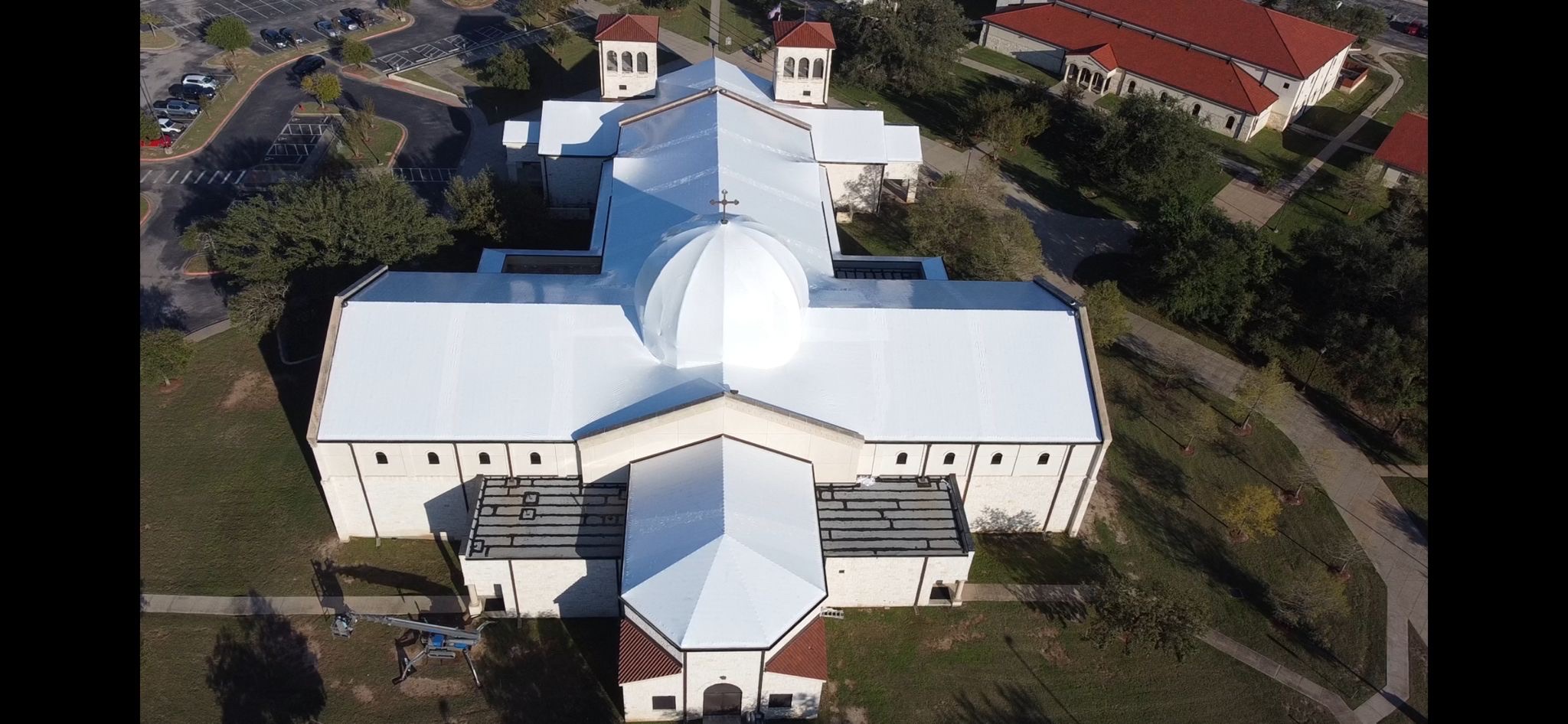 The same church sealed watertight under a continuous white Titanium Tarps Elastowrap membrane