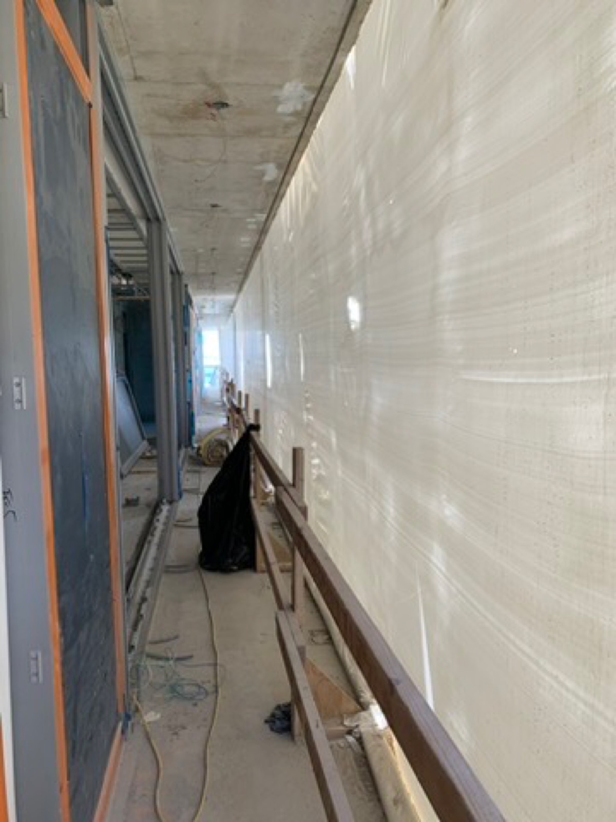Interior containment wall of white film inside an active construction site
