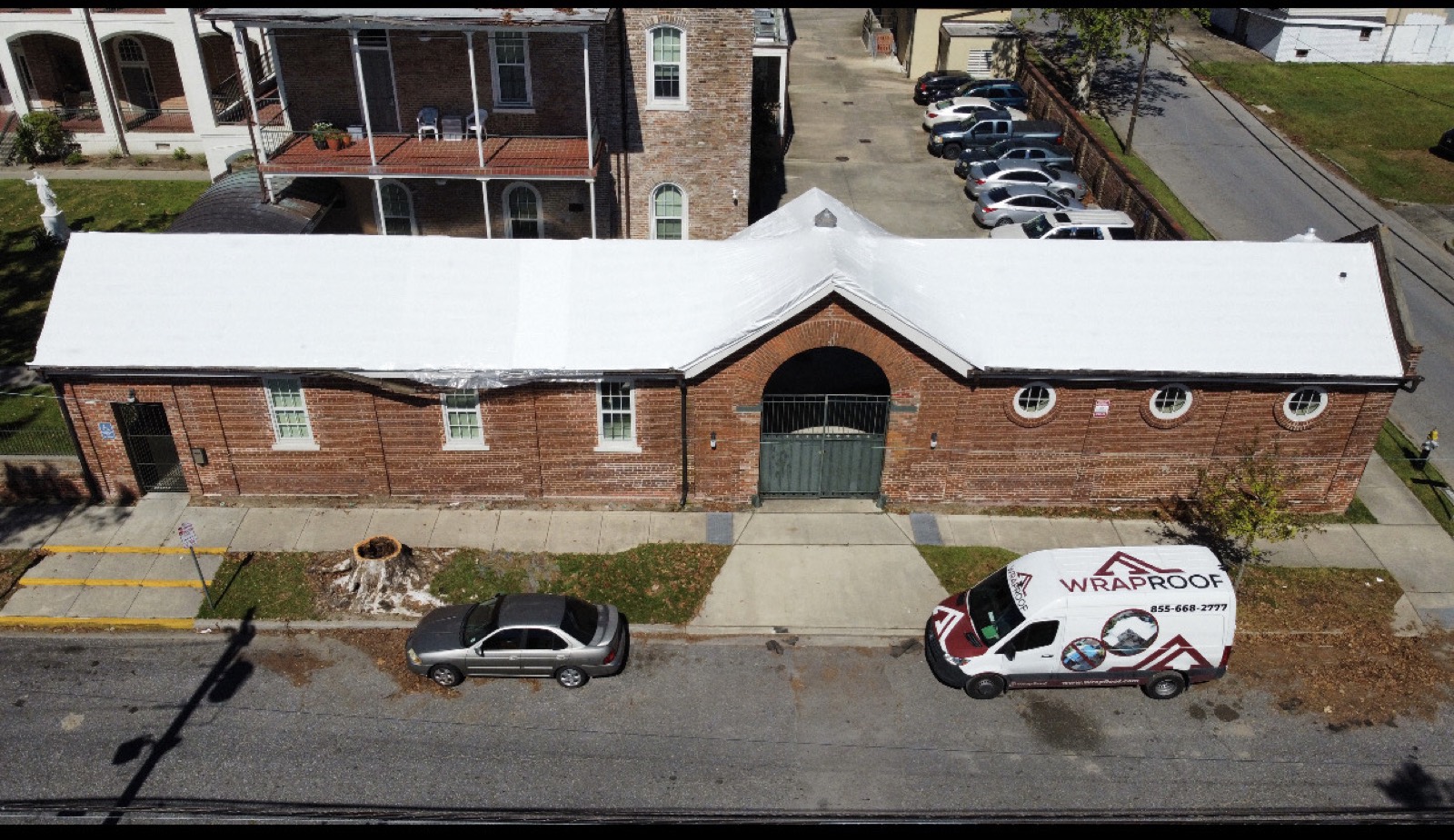 Municipal brick building on North Johnson Street sealed under a white Elastowrap roof