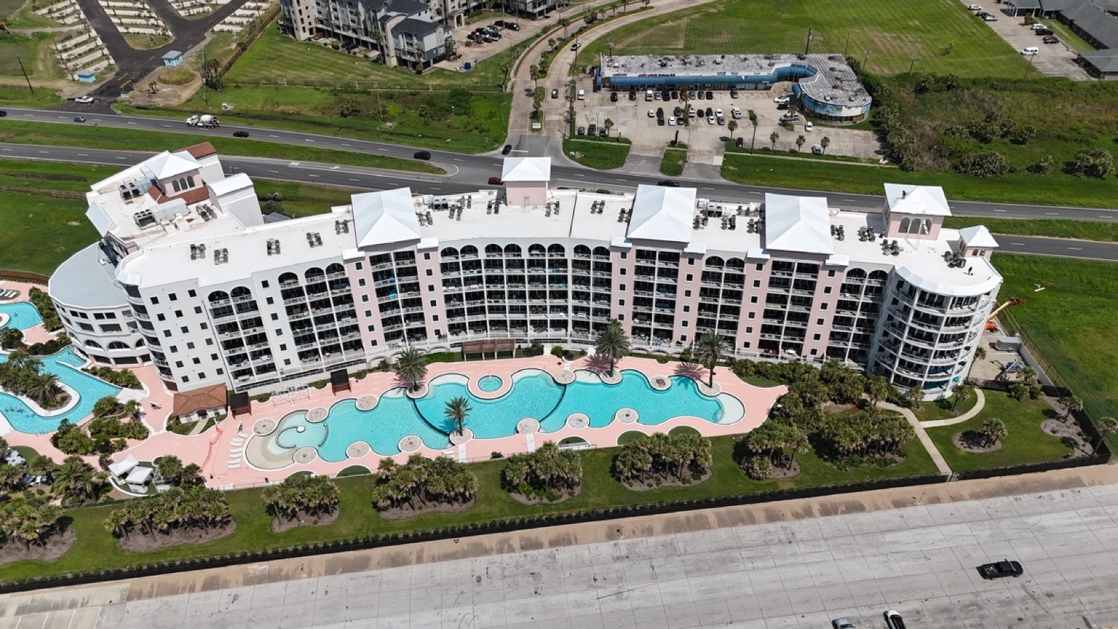 Beachfront condominium tower with shrink wrapped roofs after hurricane damage in Texas