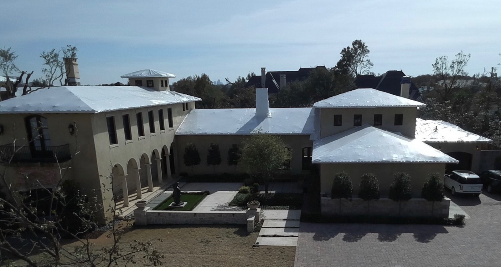Private estate with every roof plane sealed in shrink wrap film in Texas