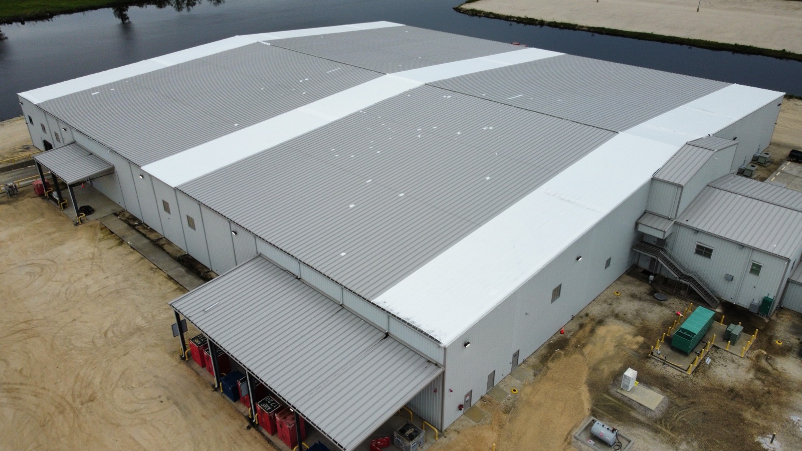The warehouse roof being sealed under white Elastowrap during installation
