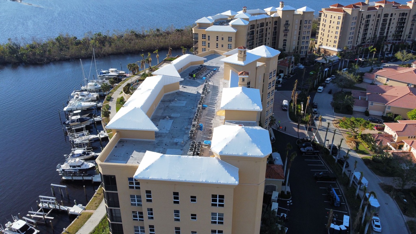 Waterfront condominiums and marina with white shrink wrapped roofs
