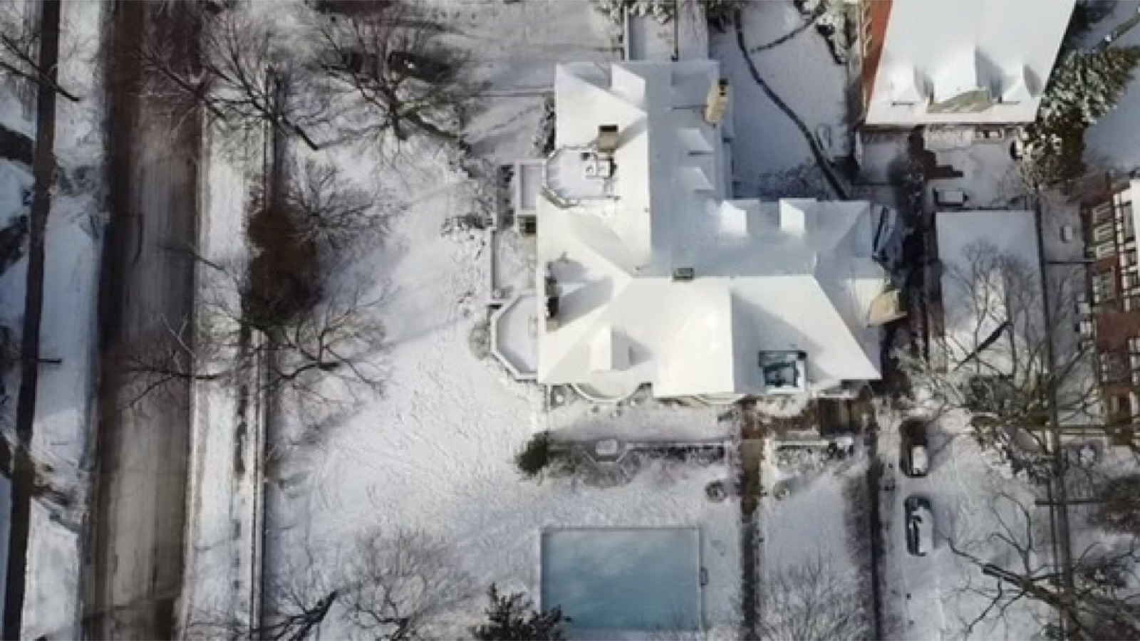 Snow covered home protected by a shrink wrap roof after a winter storm