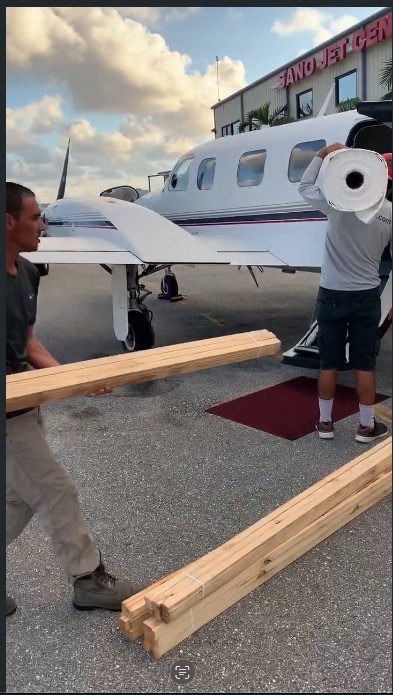 Titanium Tarps crew loading membrane and lumber into a small plane at a private jet center